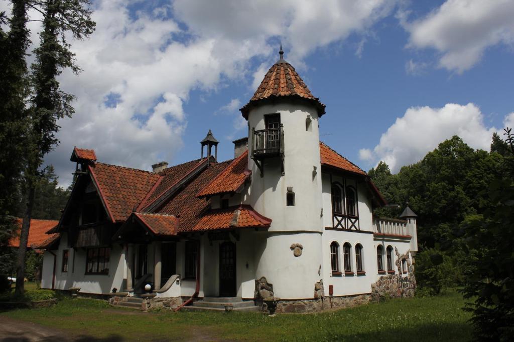 una gran casa blanca con una torre en Pensjonat Wiking, en Stare Jabłonki