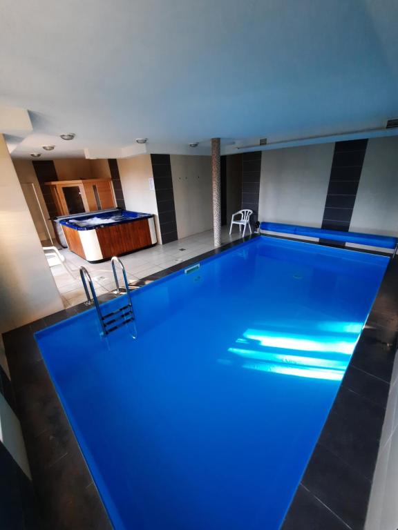 einen großen Pool mit blauer Beleuchtung in einem Zimmer in der Unterkunft Wellness Apartman in Siófok