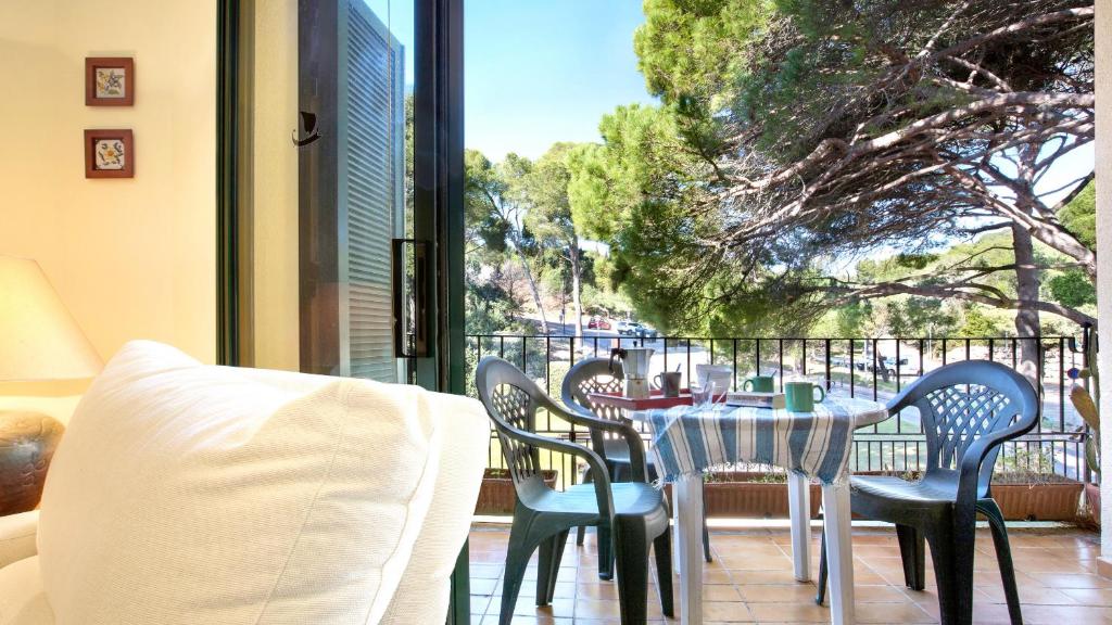 a table and chairs on a balcony with a view of a tree at Ana1 - Llafranc in Llafranc