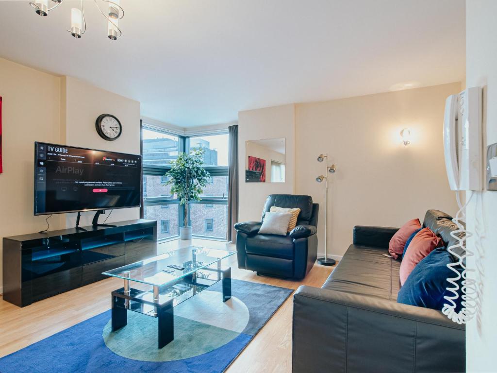 a living room with a couch and a tv at Jyde Apartments - Sheffield City Centre in Sheffield