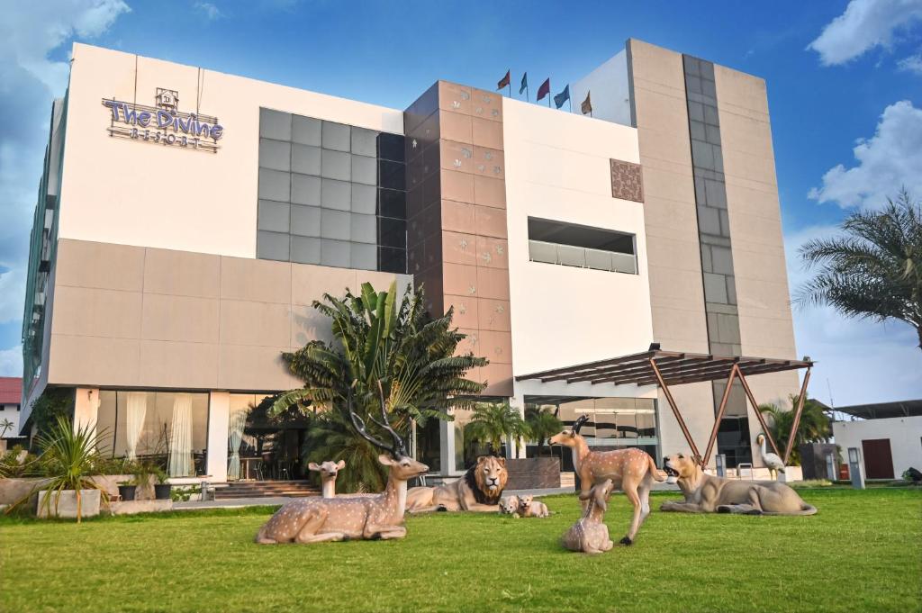 a building with statues of deer in front of it at The Divine Resort Somnath in Somnath