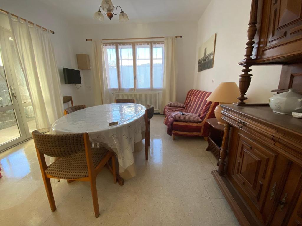 sala de estar con mesa, sillas y sofá en Chez Cathy et Alain en Saint-Laurent-dʼAigouze