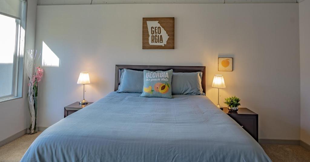 a bedroom with a bed with blue sheets and two lamps at 2BR Fully Furnished Apartment - Great location in Midtown apts in Atlanta