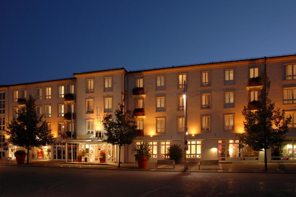 un gran edificio de apartamentos por la noche con luces en Hotel Garni Lindacher Hof, en Burghausen