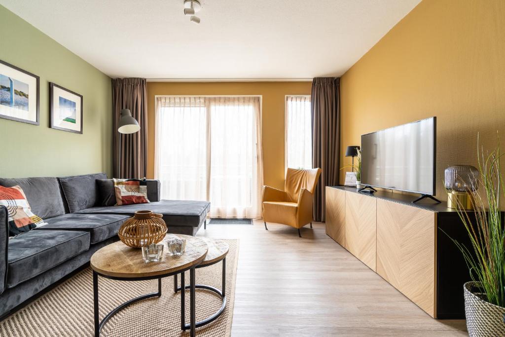 ein Wohnzimmer mit Couch und Flachbildfernseher in der Unterkunft Appartement De Bosrand, Resort Amelander Kaap in Hollum