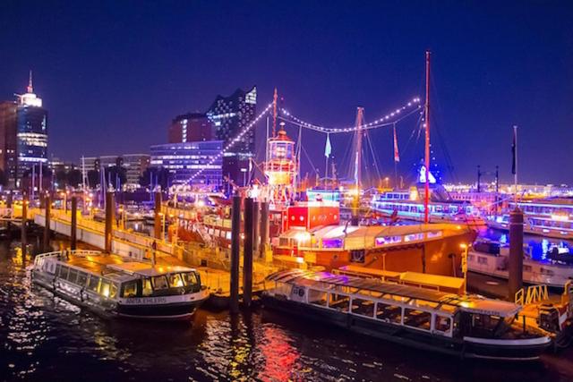 two boats are docked in a harbor at night at Das Feuerschiff in Hamburg