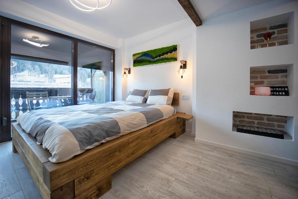 Un dormitorio con una gran cama de madera y una ventana en Studio Rubio, en Poiana Brasov