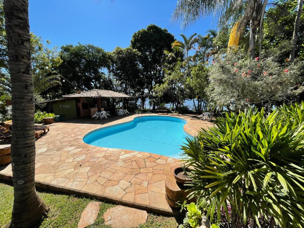 een zwembad in een tuin met een palmboom bij Casa do Lago Hospedaria in Brasilia