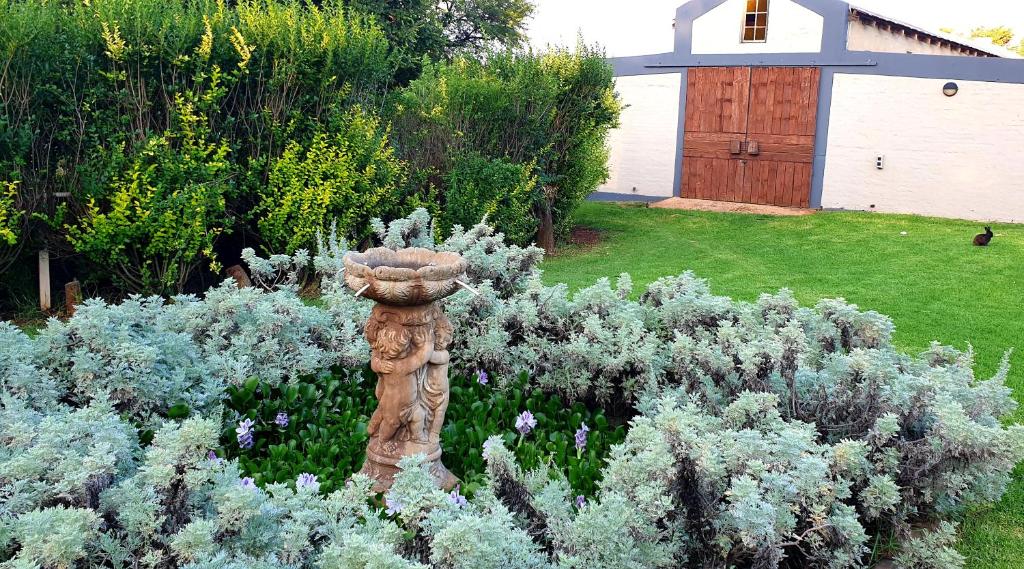a garden with a statue in the middle of a yard at Ugly Darling Farmstyle B&B in Krugersdorp