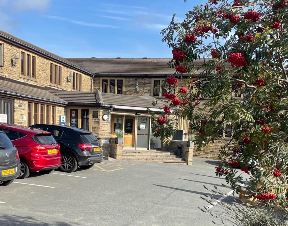 a parking lot with cars parked in front of a building at Best Western Bradford Guide Post Hotel in Bradford