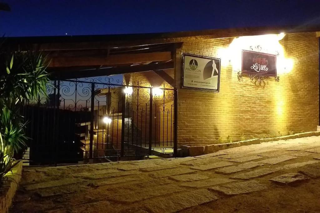 a brick building with a gate at night at La Villa Chalés in Serra Negra