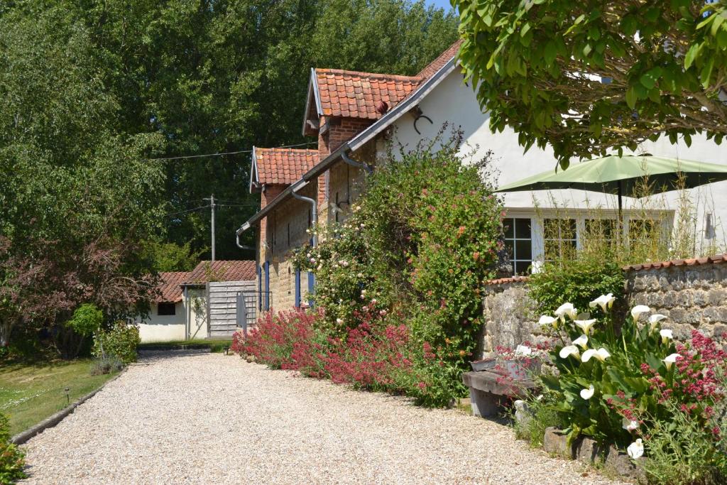une maison avec une allée en gravier et des fleurs dans l'établissement Les Chambres de Souverain Moulin, à Pernes-lès-Boulogne
