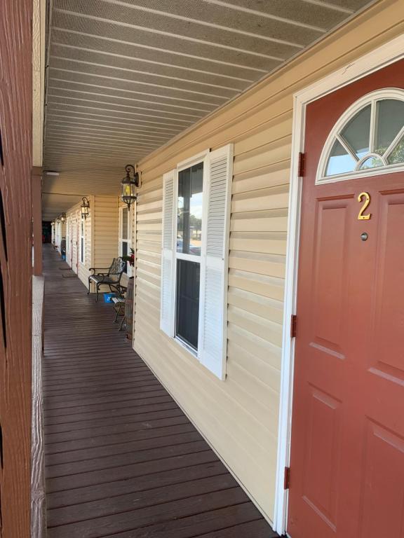 a porch of a house with a red door at Buffalo Chip's Ranch House Motel in Bonita Springs