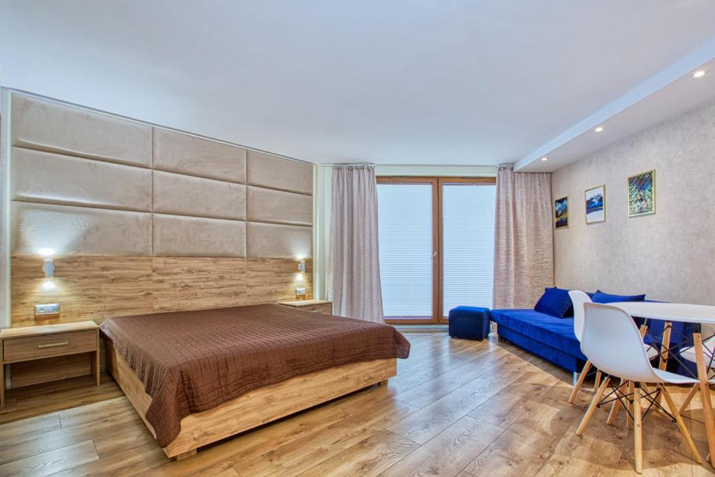 a bedroom with a bed and a blue couch at Maloves Apartament przy plaży II in Władysławowo