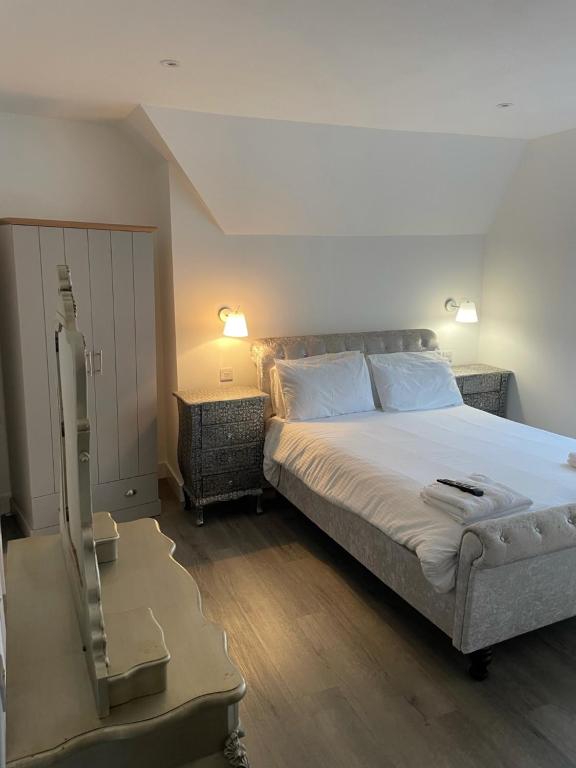 um quarto com uma cama e uma cómoda com um espelho em Duporth Guest House em Penzance