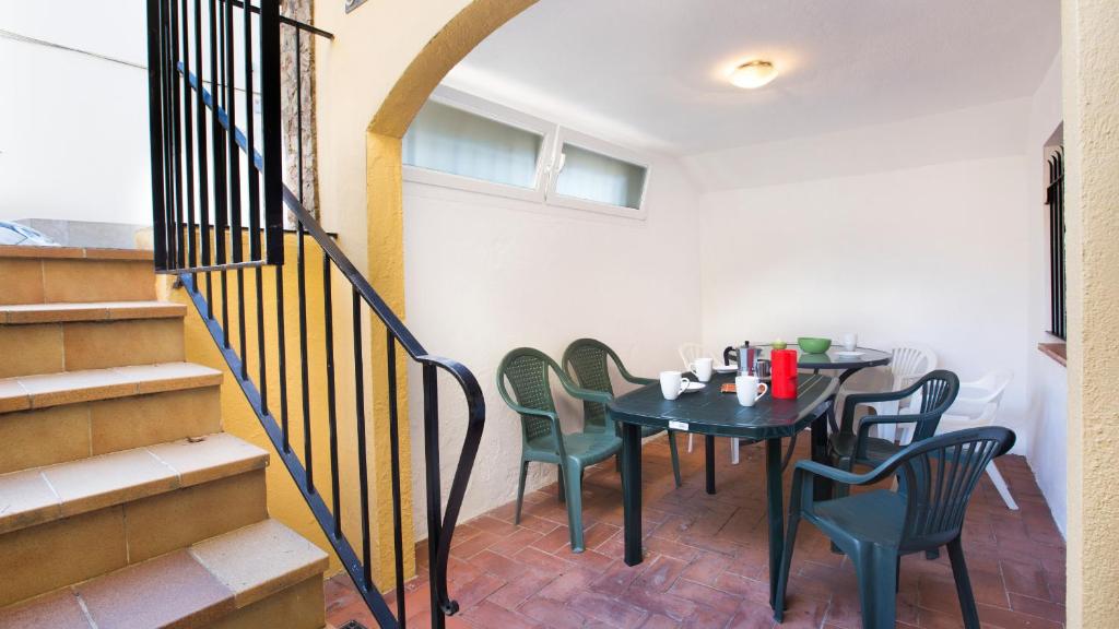 een eetkamer met een tafel en stoelen en een trap bij 1Pele PL - Llafranc in Llafranc