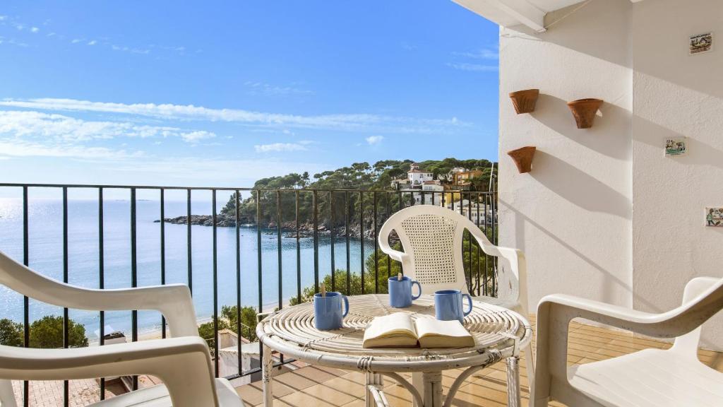 een tafel en stoelen op een balkon met uitzicht op de oceaan bij 1Prun01 Llafranc in Llafranc