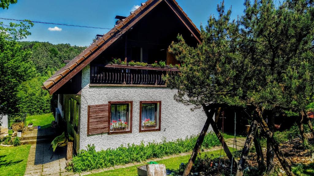 a house with a balcony with flowers on it at Chalupa U Mohelky in Bílá