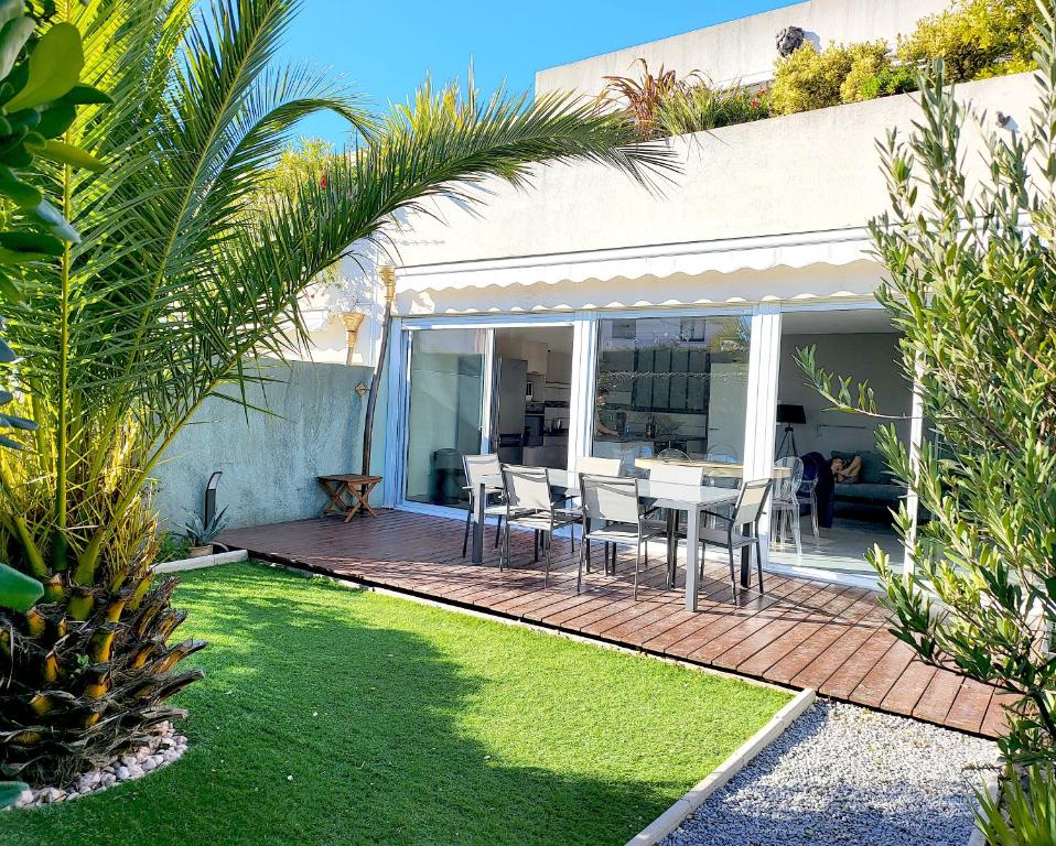 un patio con mesa y sillas en una terraza en Bandol - Résidence Premium jardin, piscine et garage, en Bandol