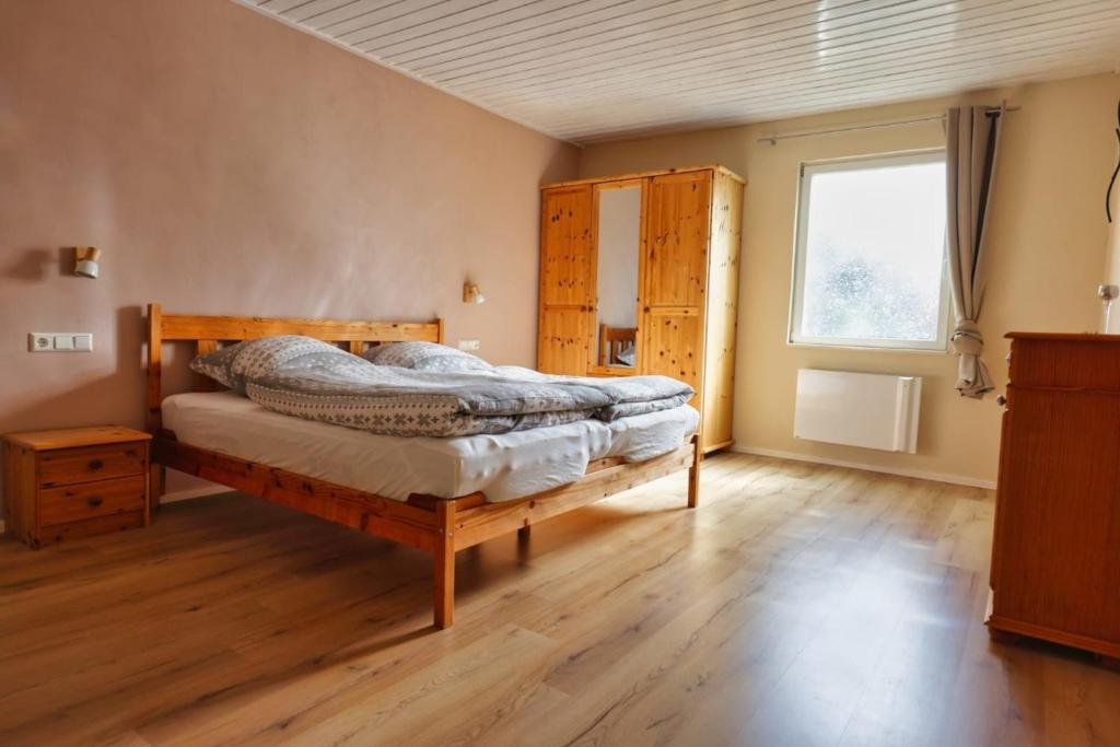 a bedroom with a wooden bed and a window at Ferienwohnung Steinberg mit Sauna in Wernesgrün