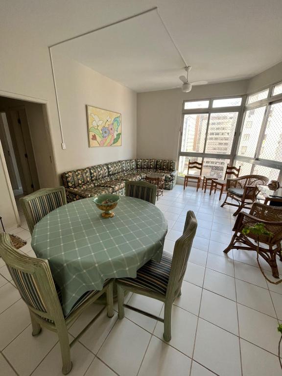 - une salle à manger avec une table, des chaises et un canapé dans l'établissement APARTAMENTO NA RUA DA PRAIA COM VISTA PARA O MAR, à Guarujá