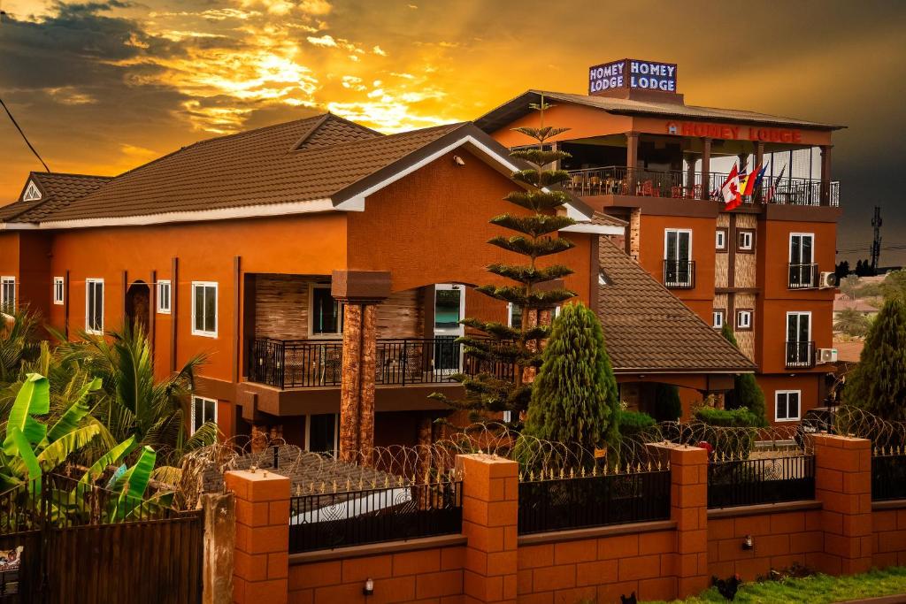 a house with a fence in front of it at Homey Lodge in Kumasi