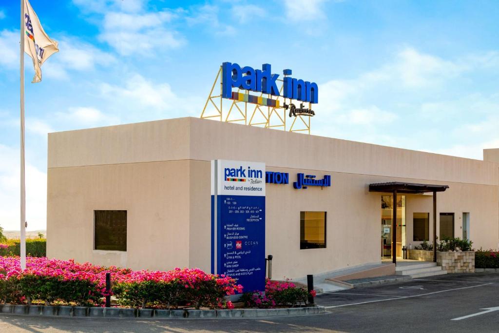 Un edificio con un cartel encima en Park Inn by Radisson Hotel and Residence Duqm, en Duqm