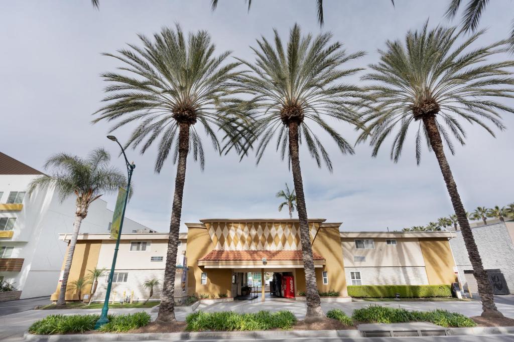 un grupo de palmeras frente a un edificio en Americas Best Value Inn & Suites Anaheim, en Anaheim