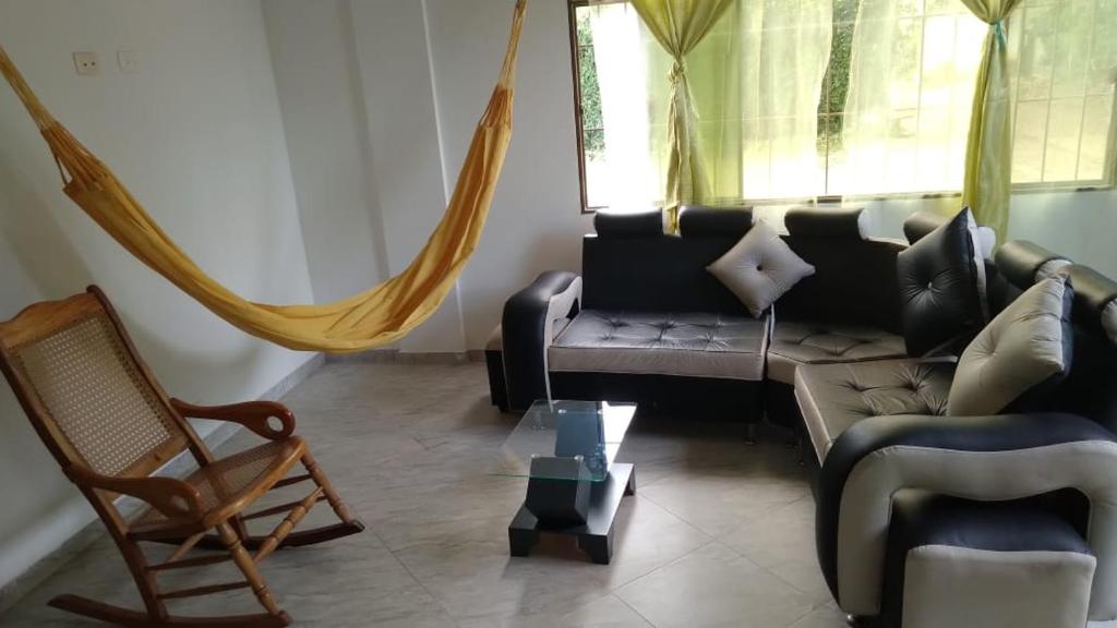 a living room with a couch and a chair at Casa en conjunto campestre, rana y bolirrana incluido. in Apulo
