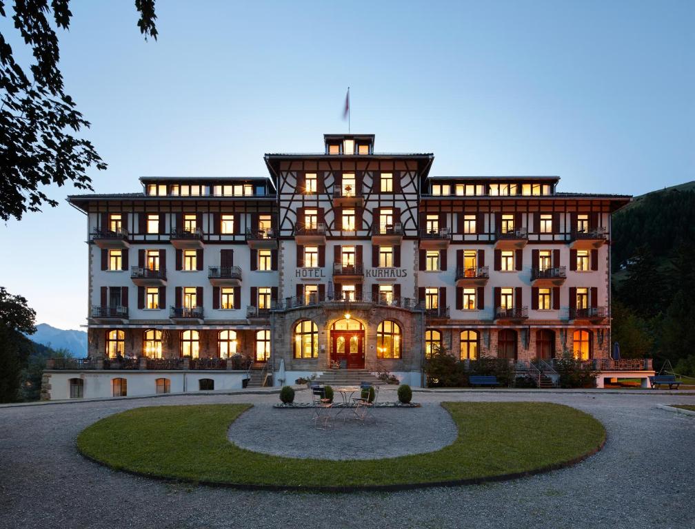 un grand bâtiment avec un cercle devant lui dans l'établissement Kurhaus Bergün, à Bergün