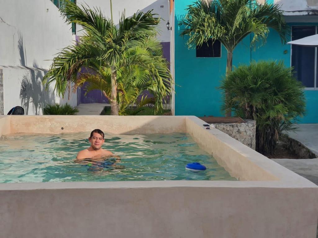 un uomo in una piscina con piscina di Hostal Xiinbal a Mérida