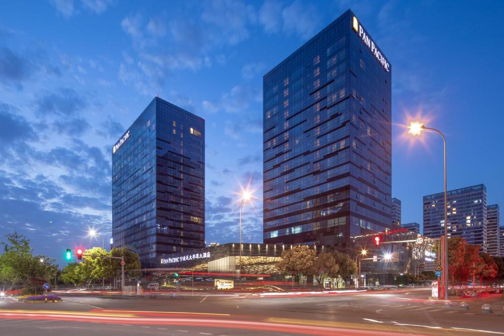 two tall skyscrapers in a city at night at Pan Pacific Ningbo in Ningbo