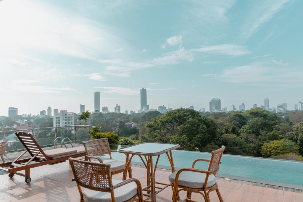 einen Balkon mit einem Tisch und Stühlen sowie Stadtblick in der Unterkunft Trillium Boutique City Hotel in Colombo