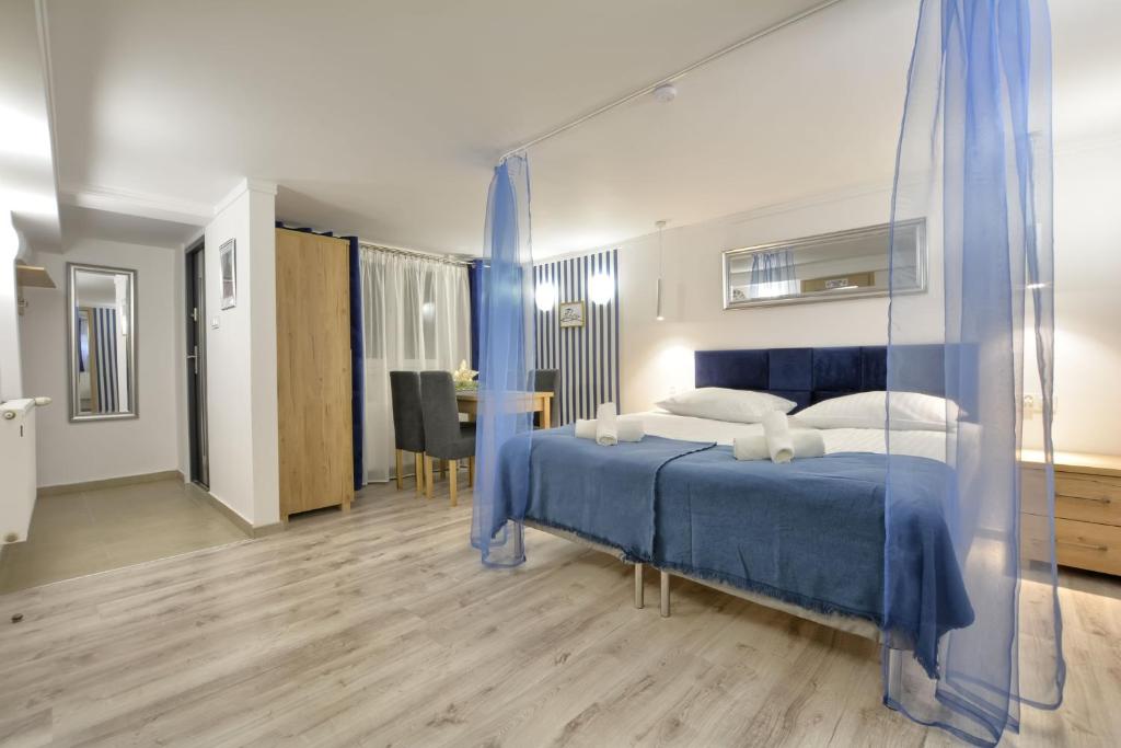 1 Schlafzimmer mit einem blauen Bett und einem Esszimmer in der Unterkunft Apartament Niebieski in Klein Öls