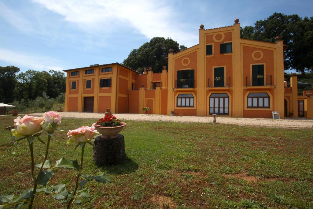 un gran edificio naranja con flores en un patio en Agriturismo La Gismonda, en Bracciano