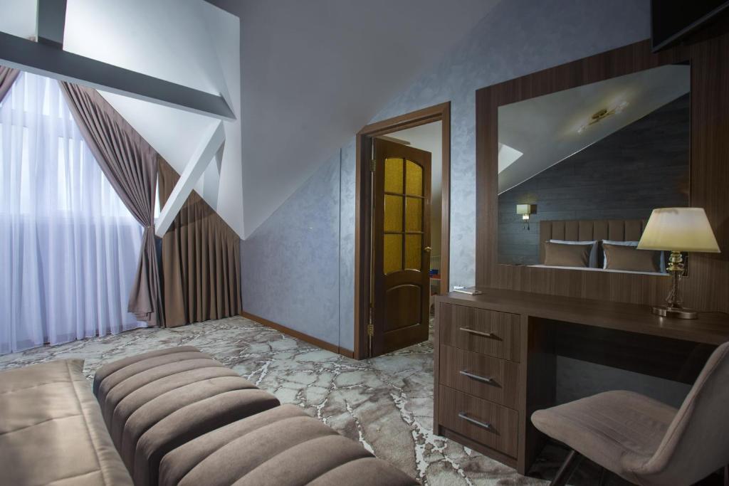 ein Schlafzimmer mit einem Spiegel, einem Stuhl und einem Schreibtisch in der Unterkunft TES-Hotel Resort & Spa in Jewpatorija