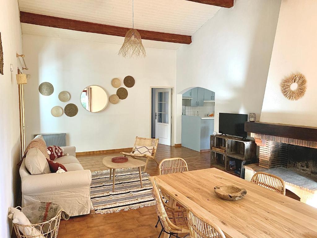 a living room with a table and a fireplace at Villa dans un cadre verdoyant , piscine et jardin in Porto-Vecchio