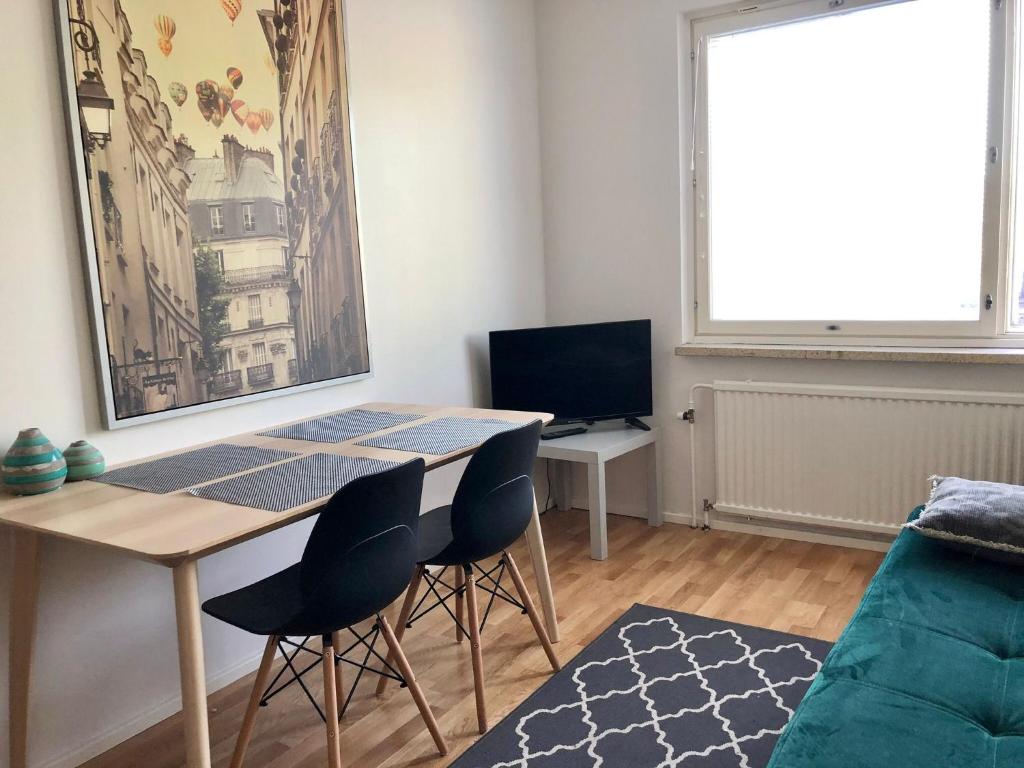 a living room with a table and chairs and a couch at Scandinavian apartments Heart of the city Kamppi 1, 5, 6 in Helsinki
