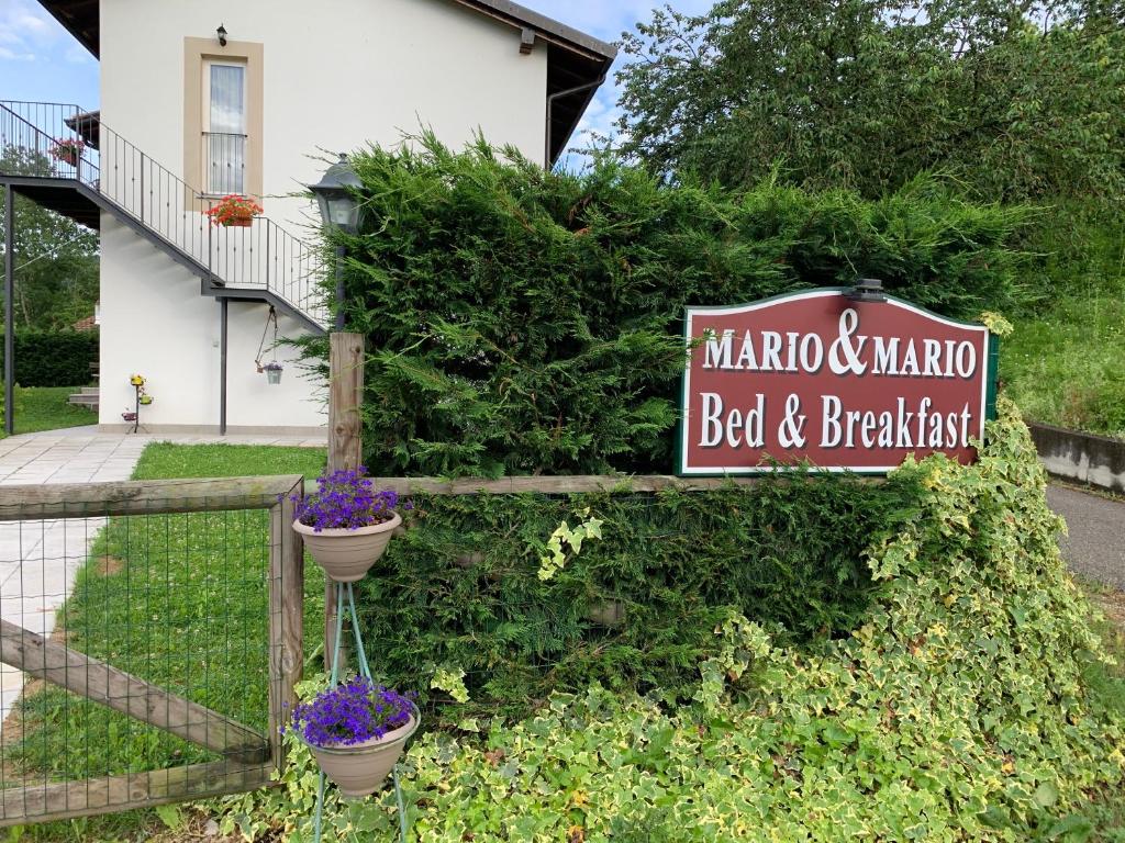 un cartel para un bed and breakfast frente a una casa en B&B Mario & Mario, en Trezzo Tinella