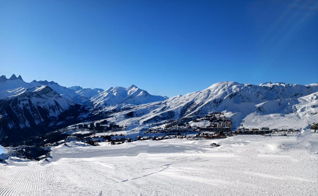 une station de ski dans les montagnes avec de la neige au sol dans l'établissement Superbe appartement à 50m des pistes parking privé, à La Toussuire