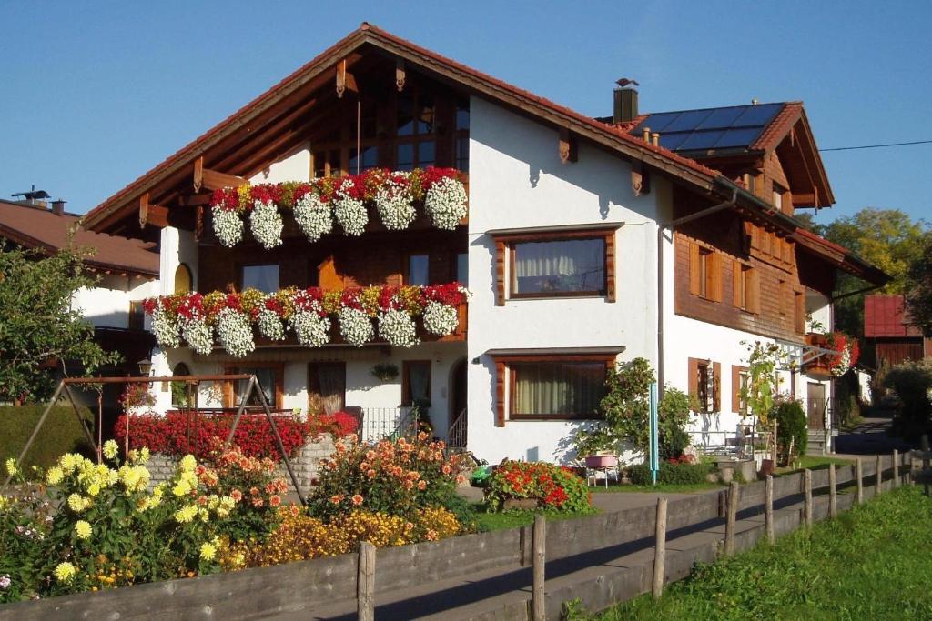 uma casa branca com flores à frente em Gästehaus Koch em Fischen