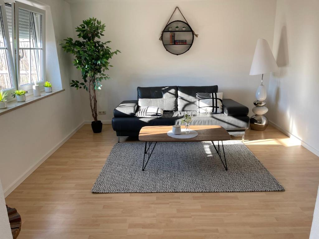 a living room with a black couch and a table at D&D Apartment in Kolbermoor