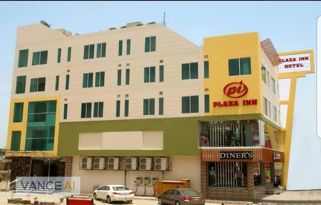 un edificio con coches estacionados frente a él en Plaza Inn Hotel, en Rahimyar Khan