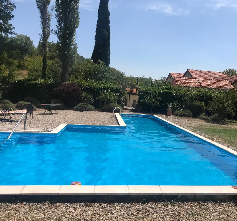 una piscina azul en un patio con una casa en Casa Ivan B&B en Tihaljina
