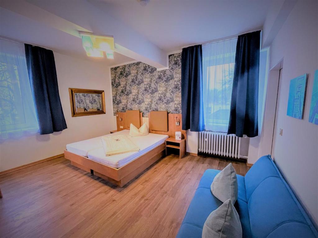 
a bedroom with a bed, a desk, and a window at Arena Hotel in Gelsenkirchen
