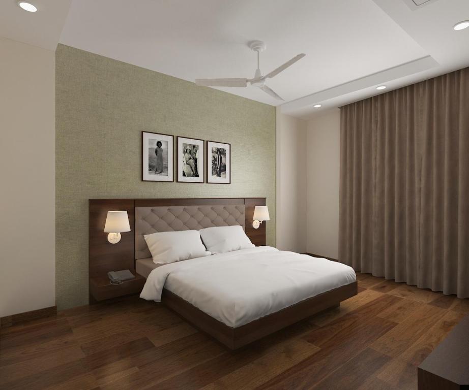 a bedroom with a bed and two pictures on the wall at Sai Maa Hotel & Residency in Puttaparthi