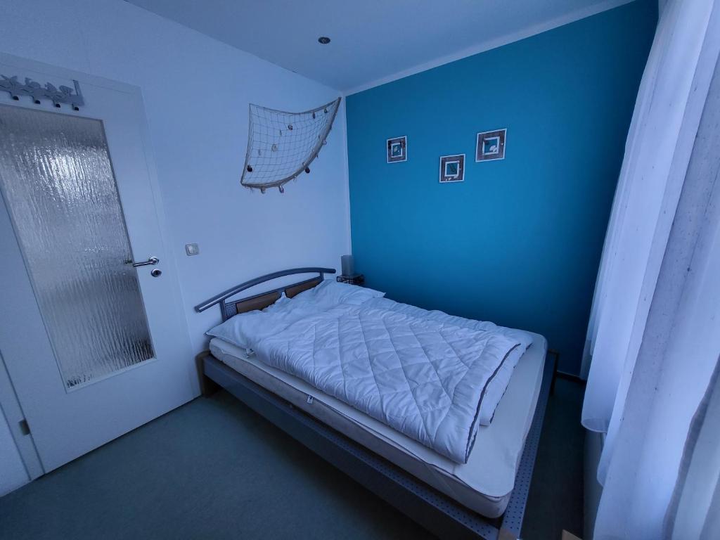 um quarto azul com uma cama e uma parede azul em Ferienwohnung Erika em Usedom Town