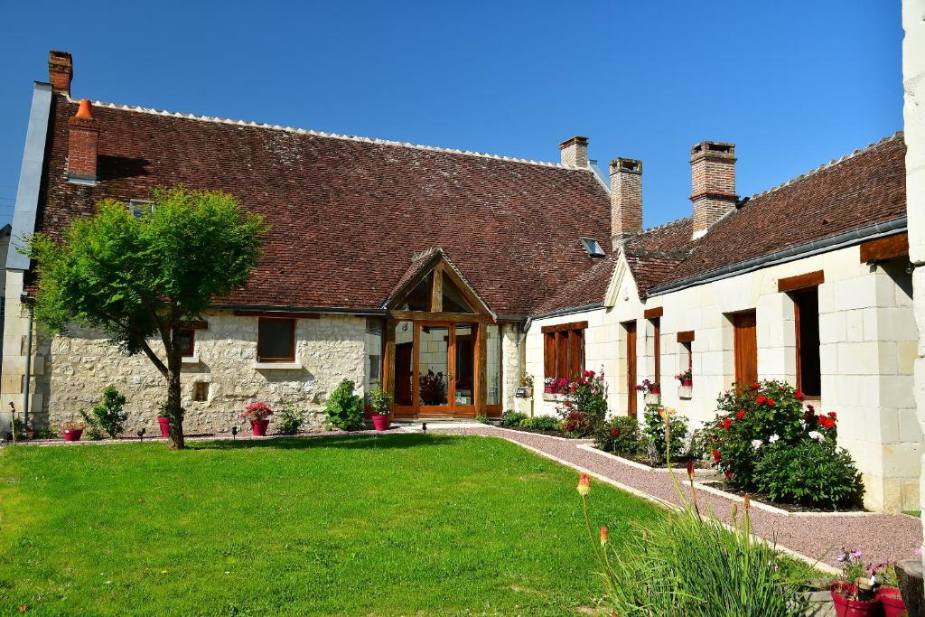 an old stone house with a lawn in front of it at Le Tulipier de Virginie in Noyers-sur-Cher