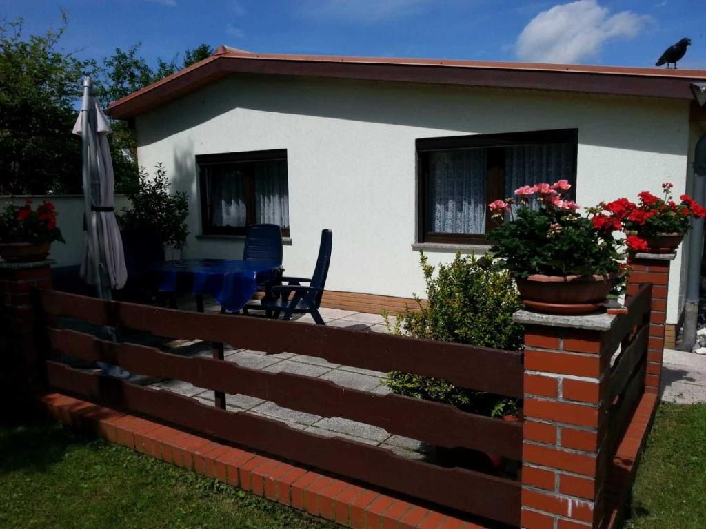 a house with a fence and a table and an umbrella at Ruegen Fewo 101 in Sagard