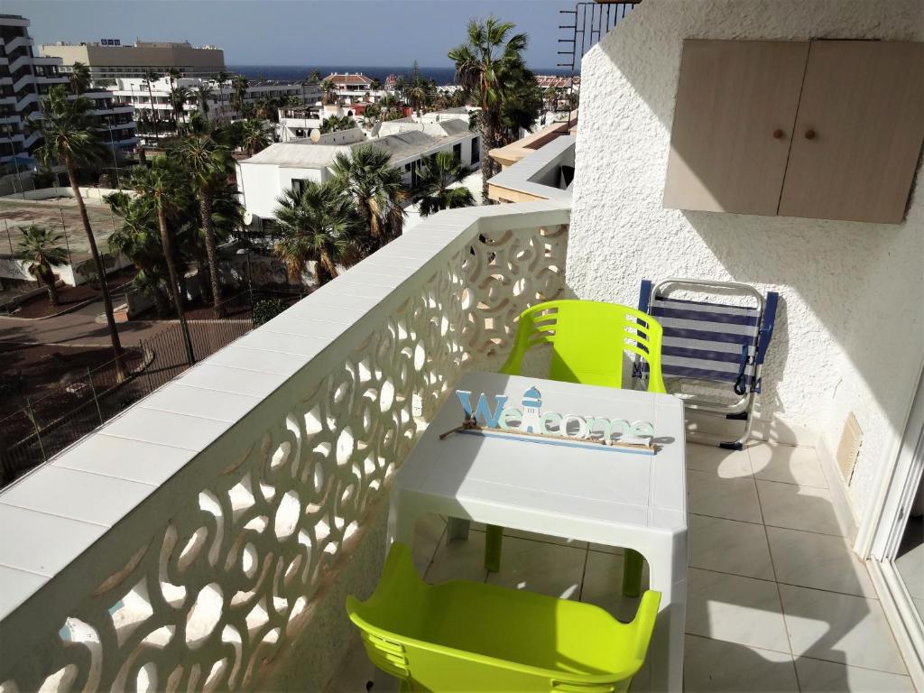 - un balcon avec des chaises jaunes et blanches dans un bâtiment dans l'établissement South facing with sea view and free WIFI in Playa Honda heart of Las Americas, à Playa de las Americas